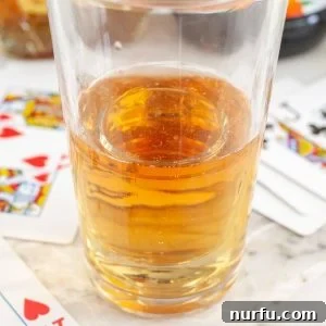Ignite Your Night: The Vegas Bomb Cocktail 6 Glass filled with energy drink and playing cards beside the glass.