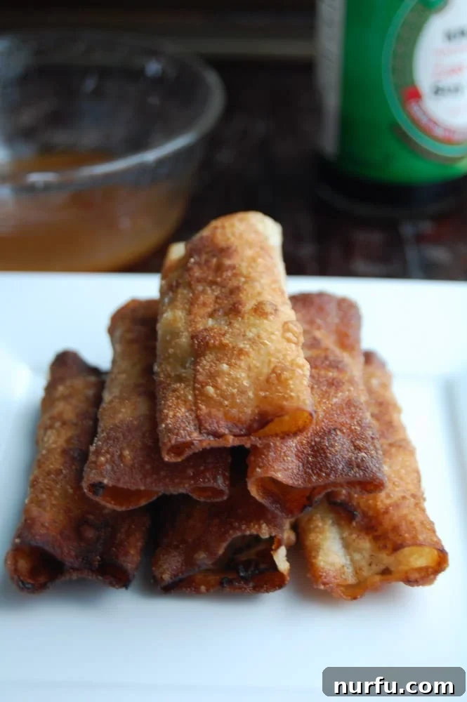 Crispy Vietnamese Spring Rolls with Tropical Pineapple Dip 2 Deliciously golden-brown Vietnamese Lumpia spring rolls piled on a white plate, ready to be served.