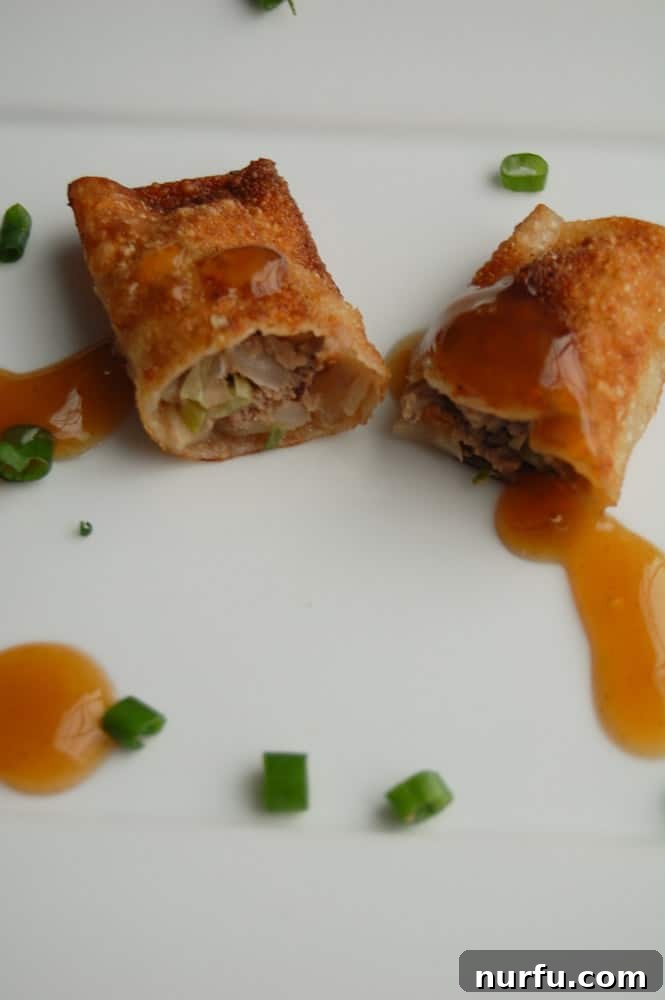 Crispy Vietnamese Spring Rolls with Tropical Pineapple Dip 7 Freshly fried, golden-brown Vietnamese Lumpia, glistening and crispy, stacked on a plate after draining, ready for dipping.