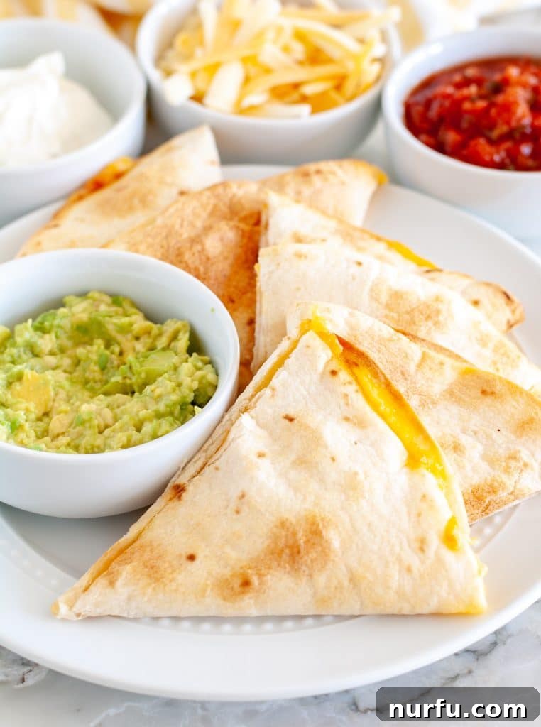 Crispy Air Fryer Quesadillas served on a plate with fresh guacamole, ready to eat.