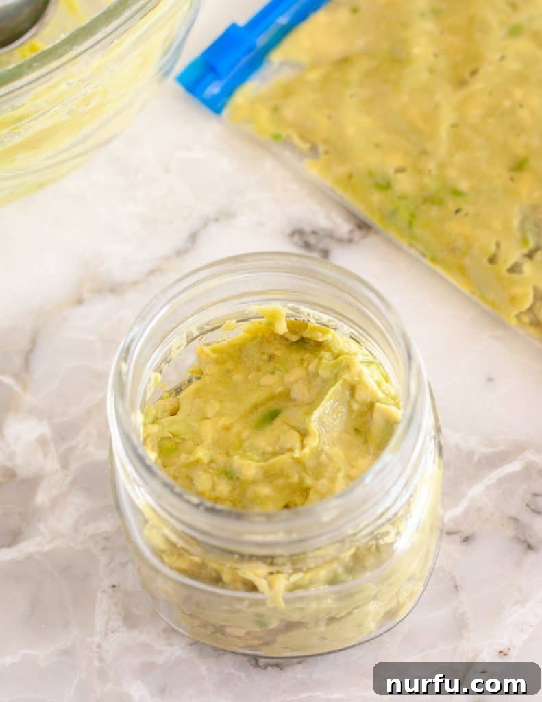 Your Guide to Freezing Guacamole 5 Guacamole stored in a freezer-safe jar with an olive oil layer, preventing browning.
