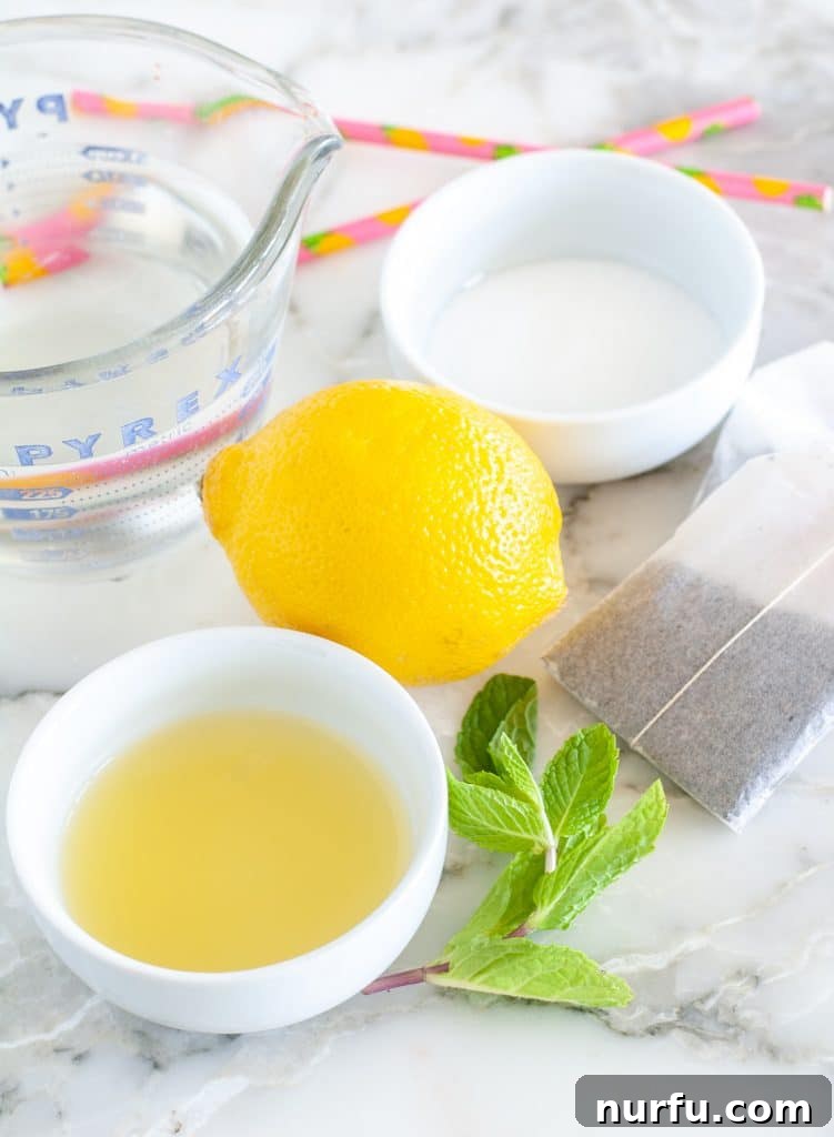 Paradise Island Iced Tea 3 Assortment of fresh ingredients for Hawaiian iced tea, including a bowl of pineapple juice, fresh lemon, mint leaves, and granulated sugar.