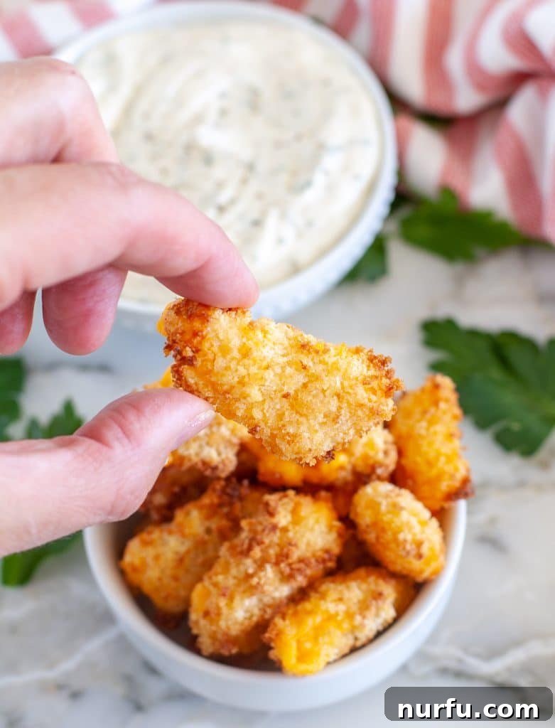 Crispy Air-Fried Cheese Bites 5 Hand holding cheese curd.