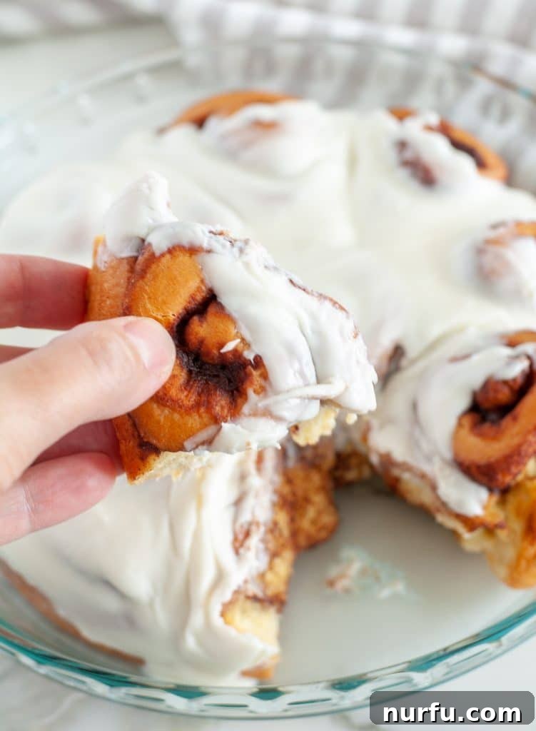 Revive Your Cinnamon Rolls 3 Genius Reheating Hacks 3 Hand holding a cinnamon roll.