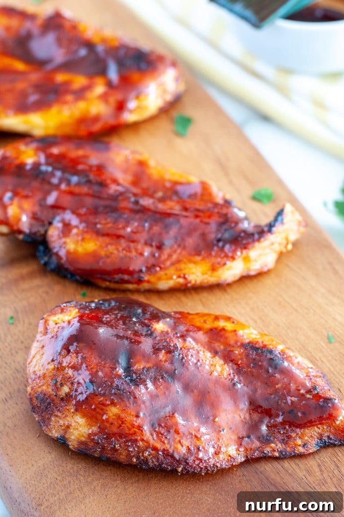 Quick and Juicy Air Fryer BBQ Chicken Breasts in 20 Minutes 2 Chicken breasts on cutting board.