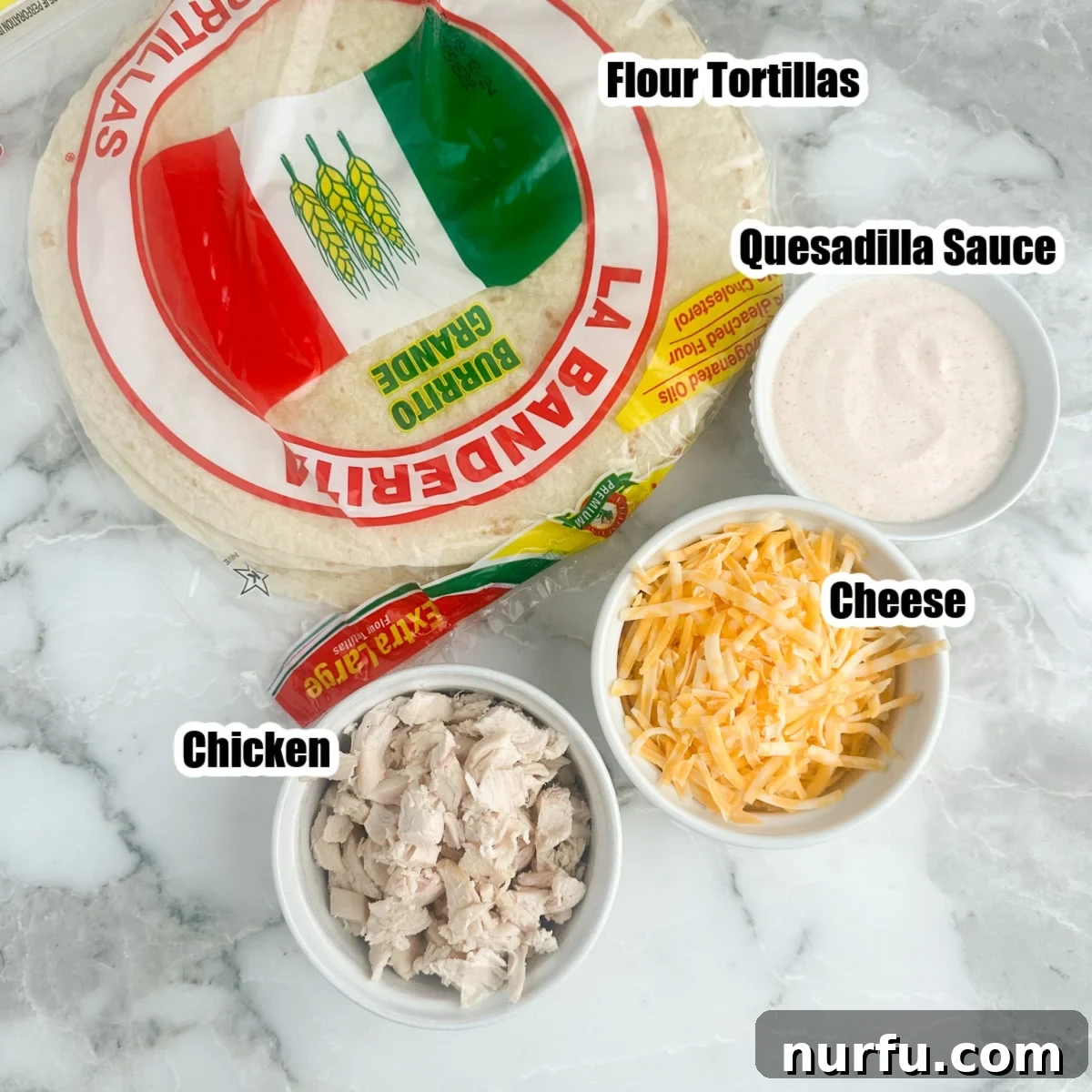 Homemade Taco Bell Chicken Quesadilla Perfection 3 A collection of fresh ingredients laid out: flour tortillas, a bowl of diced cooked chicken, a mound of shredded cheese, and a small bowl of creamy quesadilla sauce, all ready for assembly.