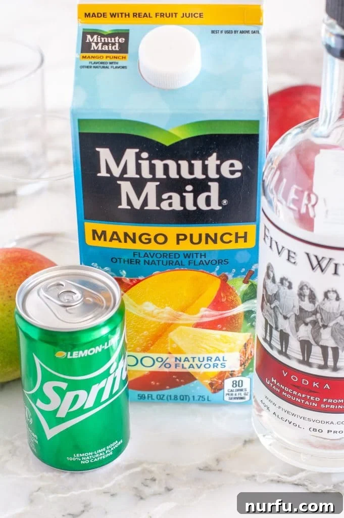 A neatly arranged flat lay of the three essential ingredients: a carton of vibrant mango punch, a sleek bottle of vodka, and a refreshing can of lemon-lime soda, ready for cocktail creation.