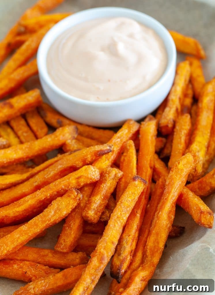 Crispy Alexia Sweet Potato Fries in the Air Fryer 2 Crispy Alexia sweet potato fries served on a plate with a side of dipping sauce, ready to be enjoyed.