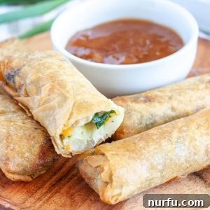 Plate of crispy spring rolls stacked for serving.