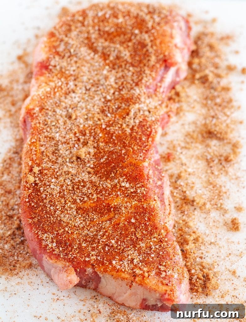 Signature Texas Roadhouse Steak Rub 4 A raw steak generously coated with Texas Roadhouse seasoning, ready for cooking.