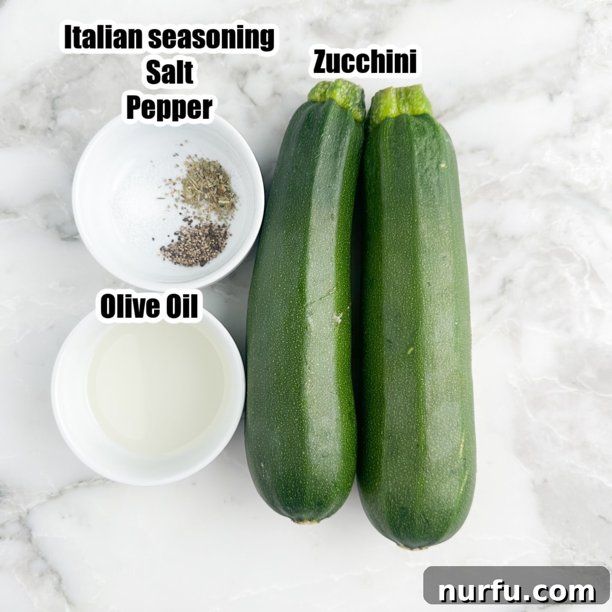Two fresh zucchinis next to a bowl of olive oil and a small dish of seasonings, ready for air frying.