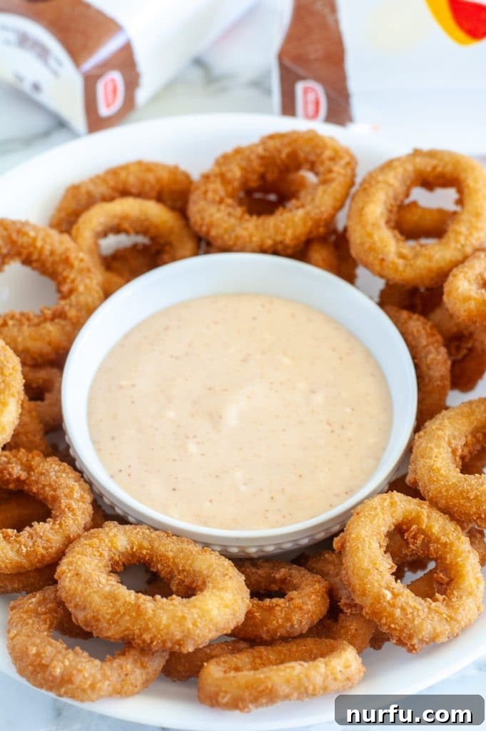 Burger King Signature Zesty Dip 2 A bowl of homemade Burger King Zesty Sauce surrounded by freshly fried onion rings, ready for dipping.