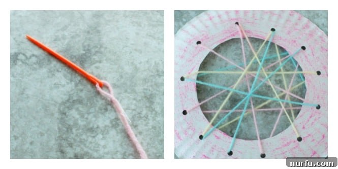 A child's hand guiding a large plastic needle with colorful yarn through one of the punched holes on a decorated paper plate, demonstrating the initial stage of weaving the web for a DIY dream catcher.