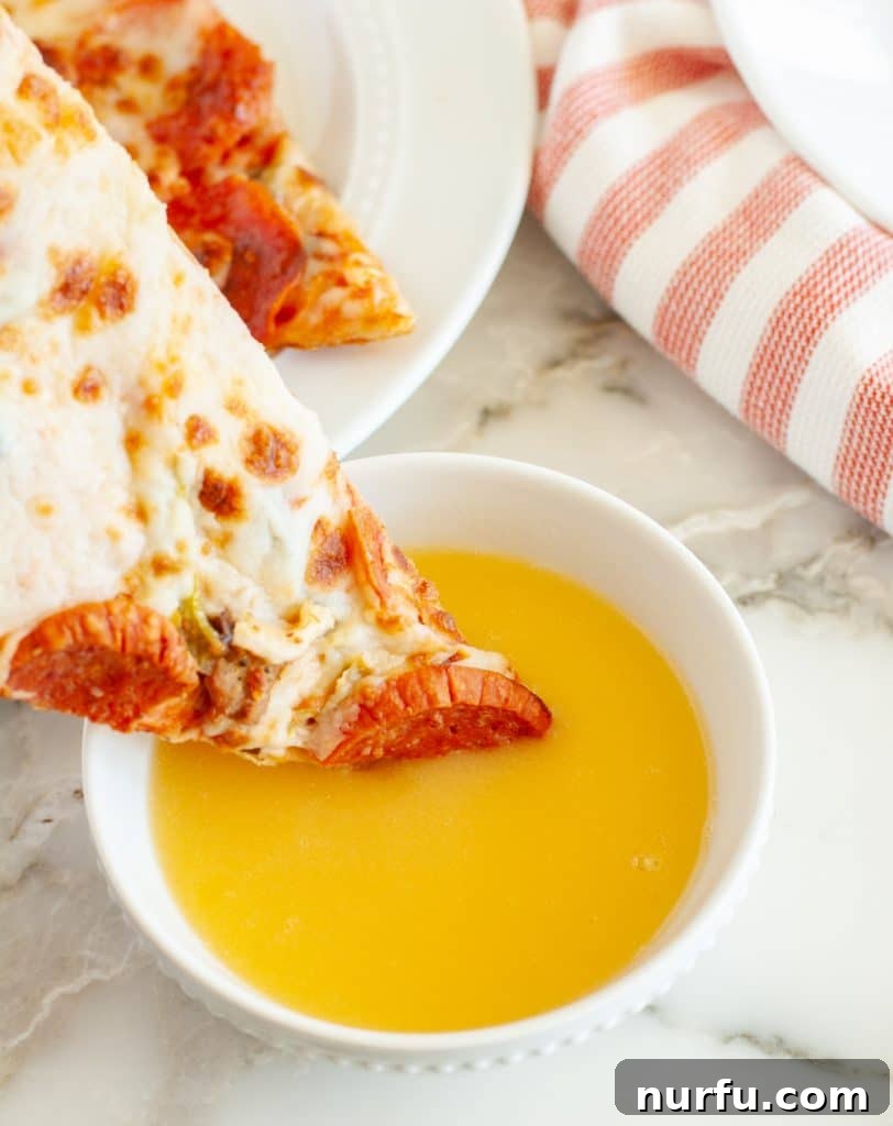 Papa John's Legendary Garlic Butter Dip 4 Slice of pizza being dipped into a bowl of Papa John's copycat garlic sauce.