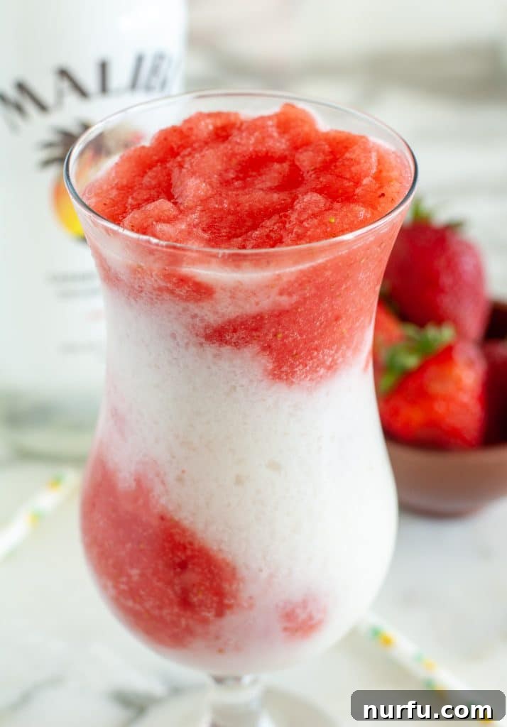 Glass filled with red and white drink.