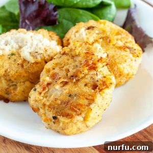 Crab cakes beautifully arranged on a plate with fresh lettuce and a lemon wedge, showcasing their golden-brown finish.