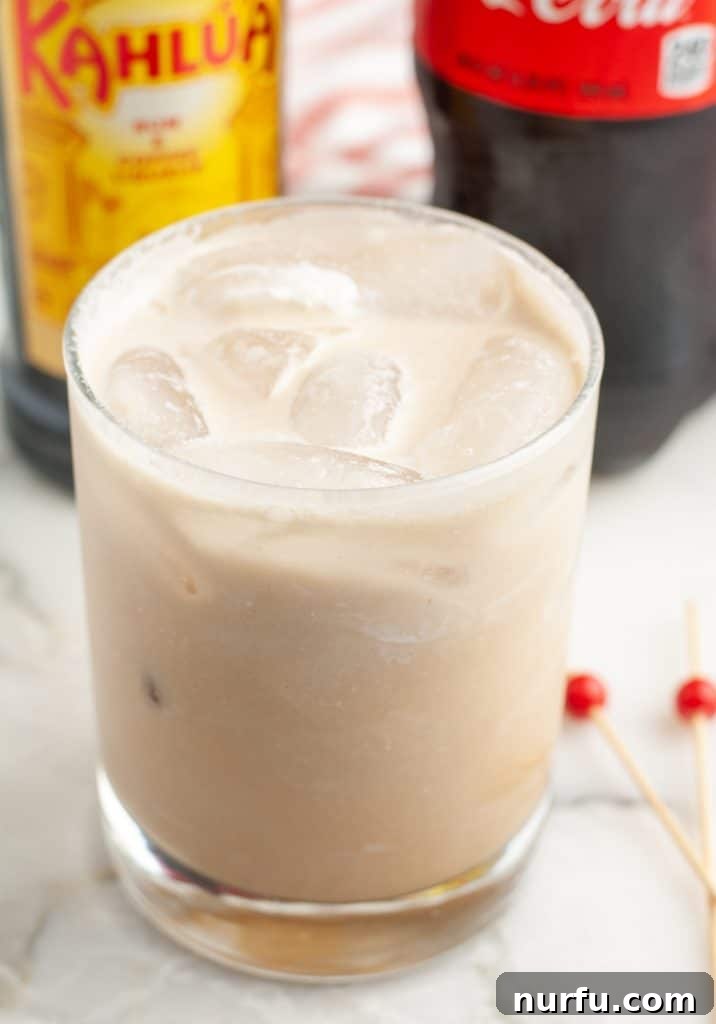 The Mile-High Bulldog 2 Creamy Colorado Bulldog drink in a clear glass with ice, garnished with a coffee bean.