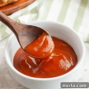 Bowl of rich red Heinz 57 sauce with a wooden spoon for serving.