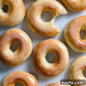 Delicious glazed donuts arranged on a table, ready to be enjoyed.