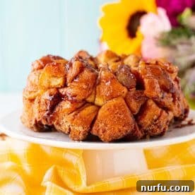 Gooey monkey bread served on a plate, glistening with sweet glaze.
