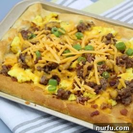 A savory air fryer breakfast pizza, loaded with eggs, sausage, and cheese, on a crispy crust.
