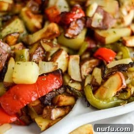 A vibrant plate of air fryer breakfast potatoes, mixed with colorful onions and peppers.