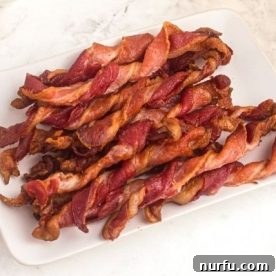 Crispy twisted bacon slices arranged on a plate.