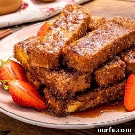 A perfectly stacked pile of golden air fryer French toast sticks.