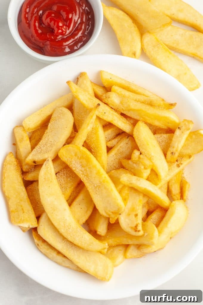 A close-up shot of a bowl filled with golden and crispy steak fries, seasoned to perfection and ready to be served.