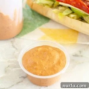 Orange colored sauce in a cup.