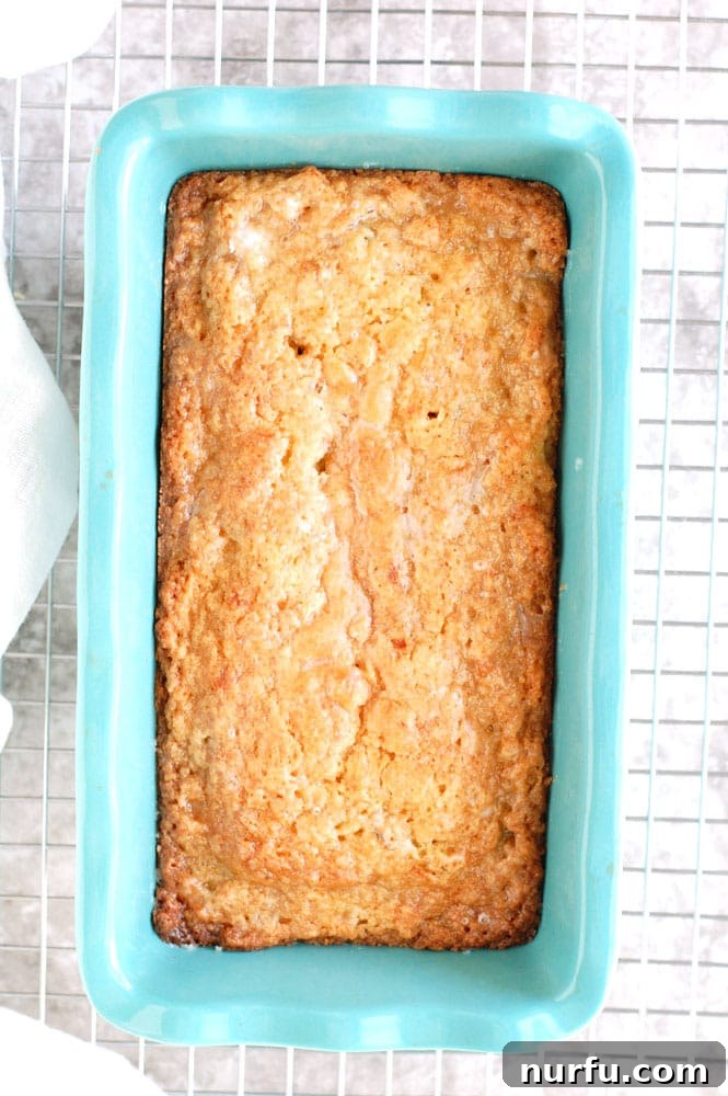 Freshly baked Zucchini Bread cooling in a blue baking dish on a wire rack.