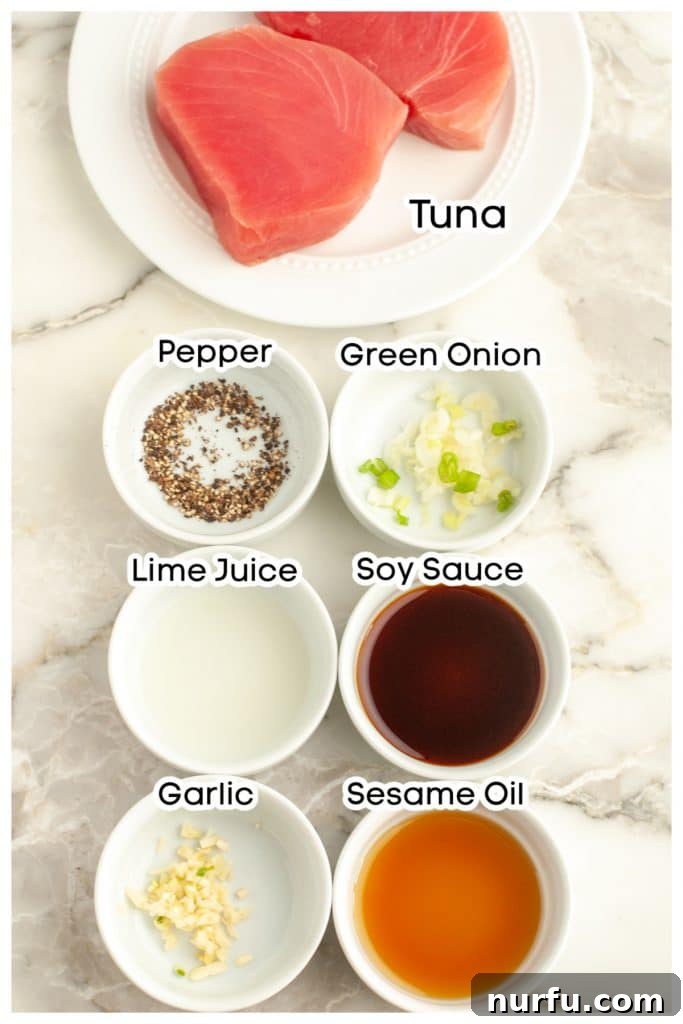 Perfect Air-Fried Tuna Steaks 2 Collection of ingredients for air fryer tuna steak, including tuna, lime juice, soy sauce, sesame oil, garlic, and green onion.