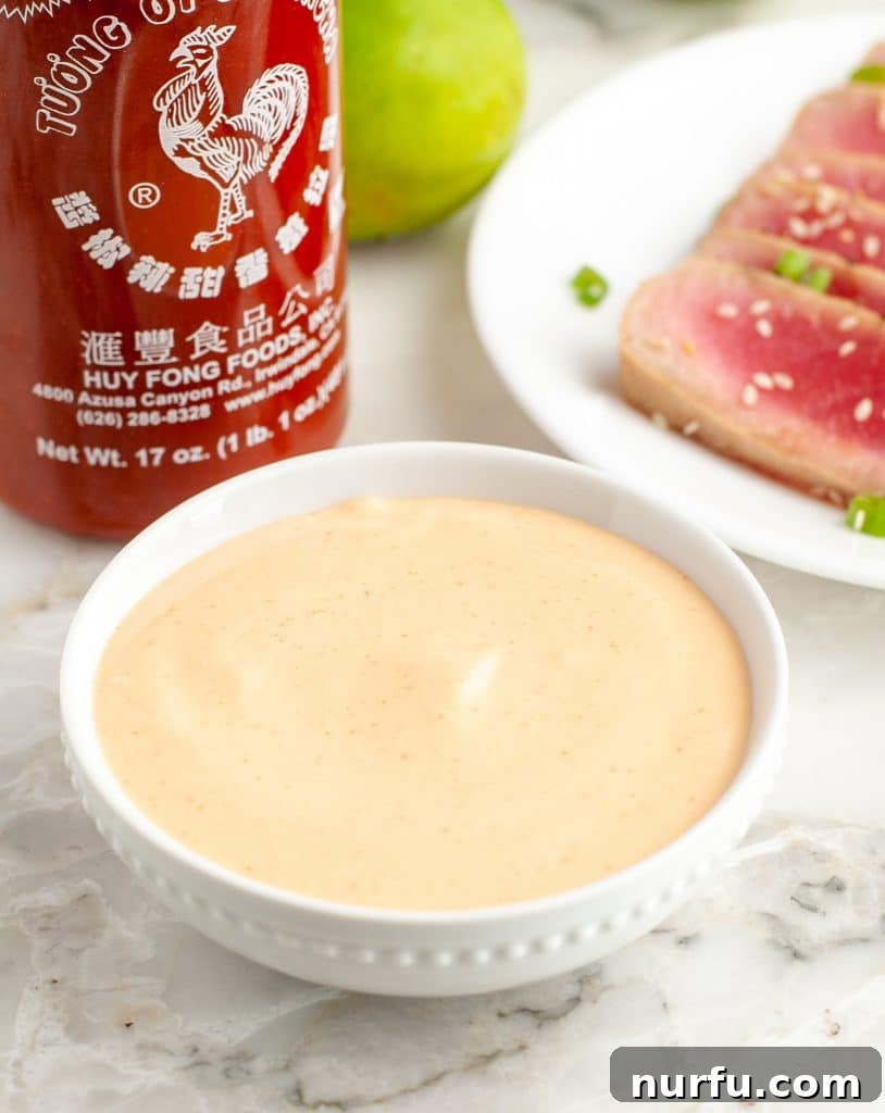 Fiery Sriracha Mayonnaise 2 A bowl of creamy, orange-hued Sriracha mayonnaise, ready to be served.