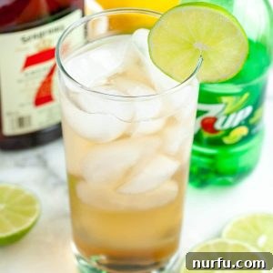 The Lucky Seven Highball 4 Glass filled with a drink and lime slice.
