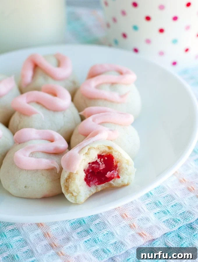 Cherry Bon Bon Cookies on a Plate A beautifully arranged plate of Cherry Bon Bon Cookies, showcasing their festive pink frosting and inviting appearance