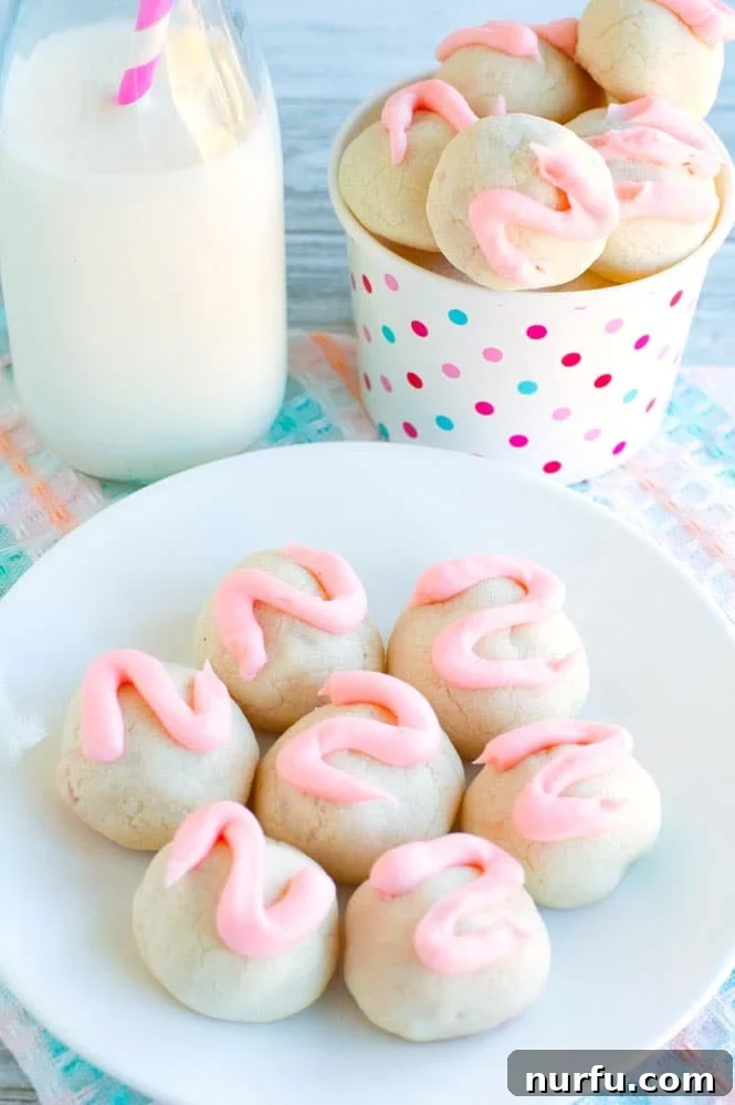Cherry Bon Bon Cookies with Milk Cherry bon bon cookies beautifully arranged on a white plate next to a tall glass of milk, suggesting a perfect snack
