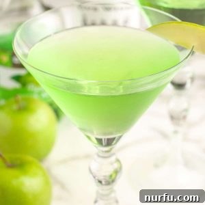 Master the Appletini: Simple Steps to a Tart Apple Martini 5 A vibrant green Appletini served in a classic martini glass, garnished with a thinly sliced green apple.