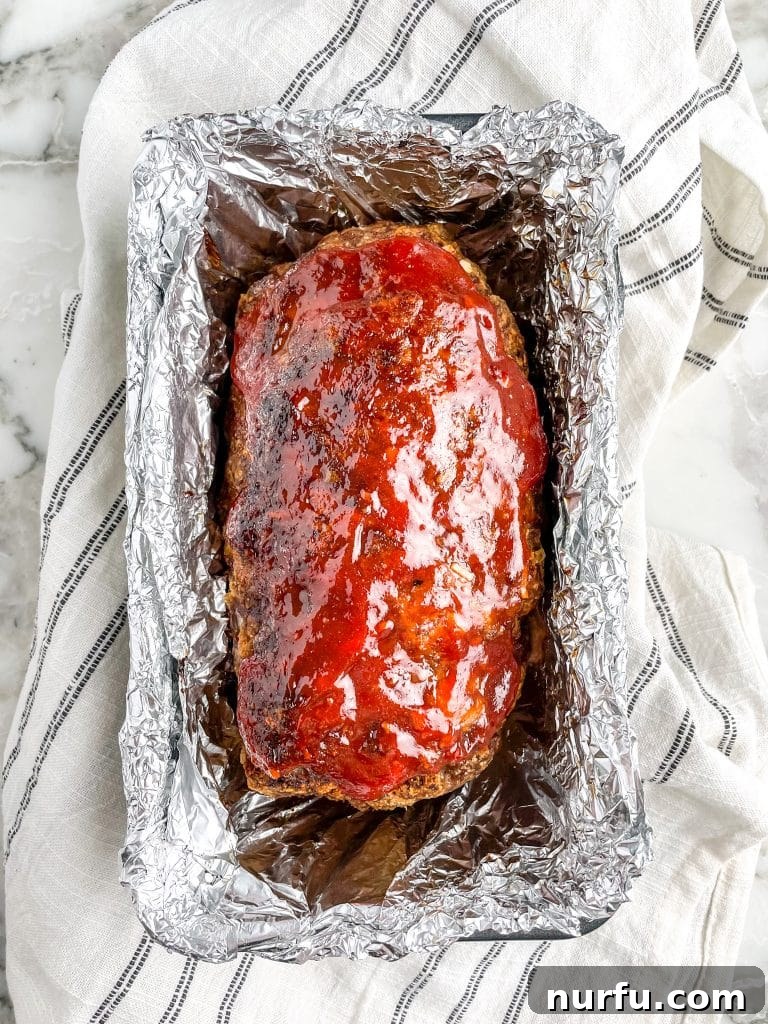Savory Lipton Onion Soup Meatloaf 7 A perfectly cooked Lipton Onion Soup Meatloaf nestled in a classic loaf pan, ready to be sliced and served, showcasing its golden-brown crust.