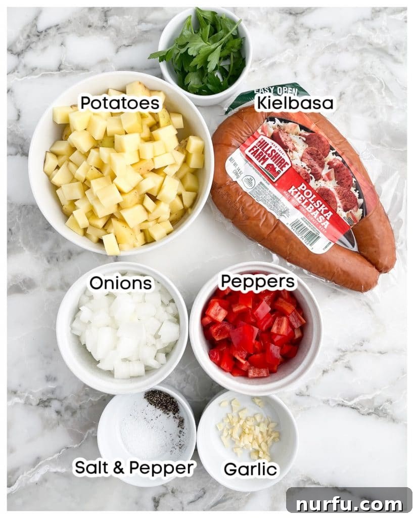 Individual ingredients for a kielbasa and potatoes skillet: sliced kielbasa, uniformly diced potatoes, chopped onions, vibrant bell peppers, and minced garlic.