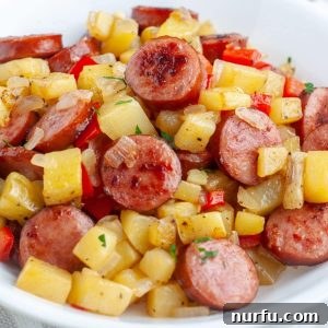 A perfectly cooked bowl of sausage and potatoes, garnished and ready to be enjoyed.