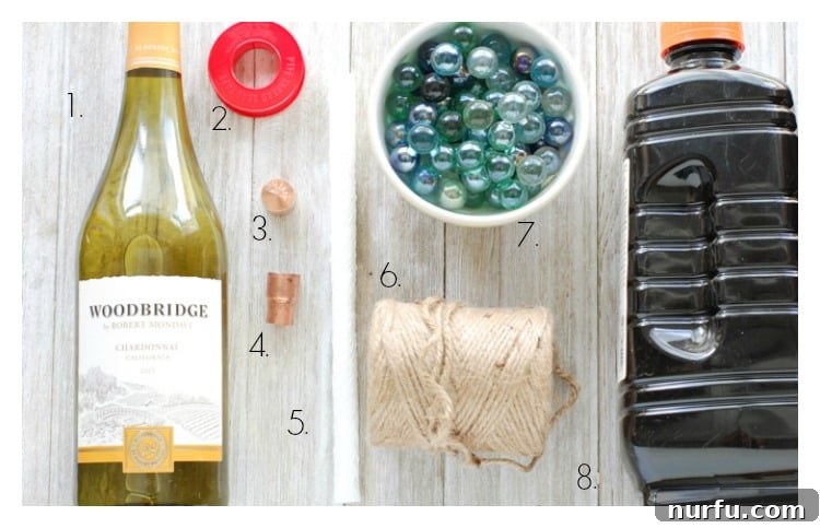 All the materials laid out on a table for making DIY wine bottle tiki torches, including an empty wine bottle, copper fittings, wick, and citronella fuel.