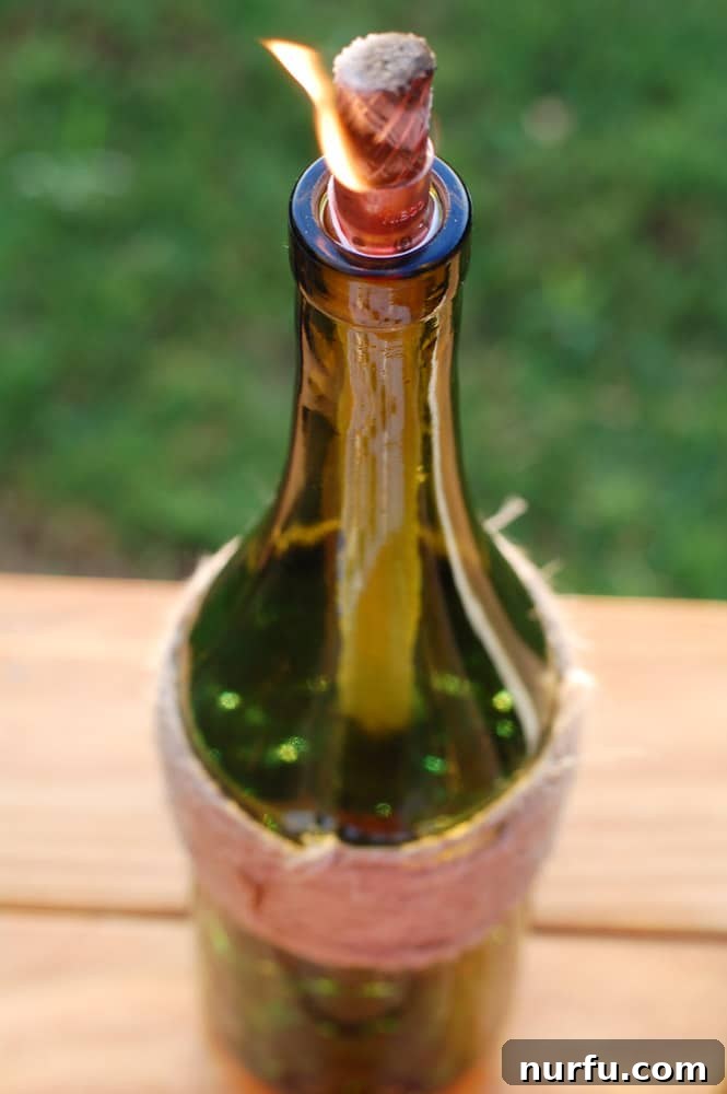 Close-up of a copper coupling being wrapped with Teflon tape and a tiki wick inserted, showing the preparation of the wick assembly.