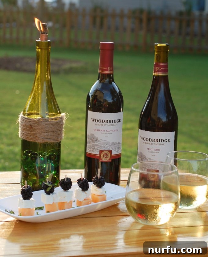 A DIY wine bottle tiki torch filled with fuel and the wick inserted, ready to be lit for an evening of bug-free entertaining.