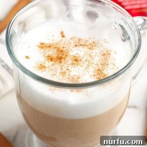 Whip Up Starbucks Chai At Home 7 A perfectly prepared chai tea latte in a mug, garnished with a light dusting of cinnamon.