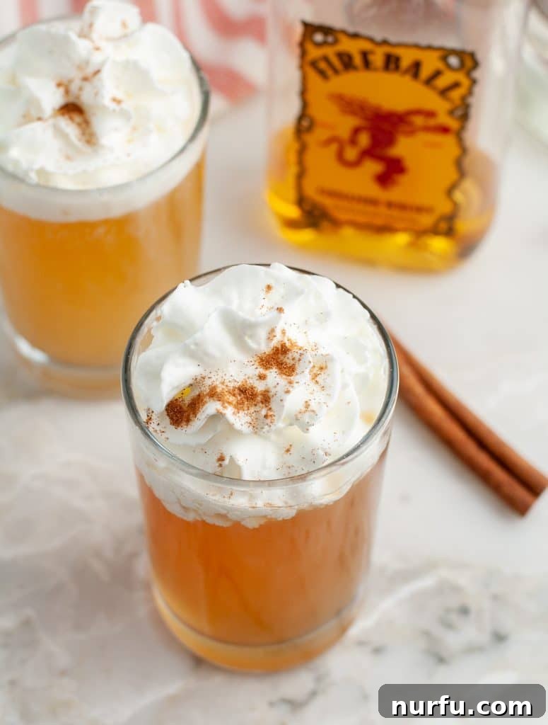 Spiced Apple Pie Shooter 5 A larger glass filled with an Apple Pie Cocktail, topped with whipped cream, showing how the shot recipe can be scaled up into a full-sized drink for extended enjoyment.