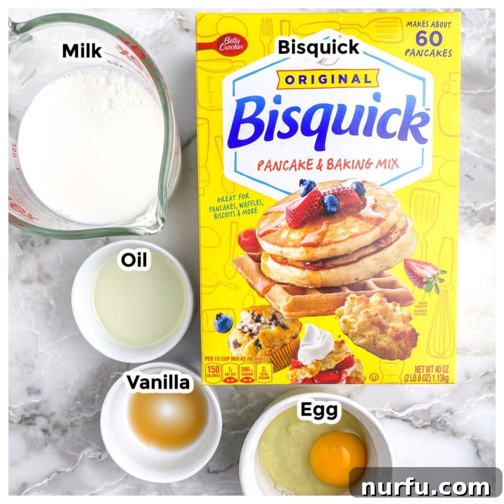 Fluffy Bisquick Waffles Made Easy 3 Individual ingredients for Bisquick waffles laid out on a kitchen counter: a box of Bisquick, a bowl of vegetable oil, a bottle of vanilla extract, a single egg, and a jug of milk.