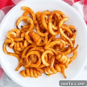 Bowl of crispy air-fried curly French fries.