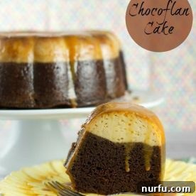 A slice of a chocolate flan site on a plate, the whole flan can be seen on a cake stand in the background