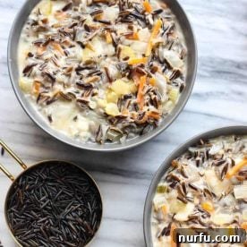 Bowl of Minnesota Wild Rice Soup, creamy and garnished with herbs.