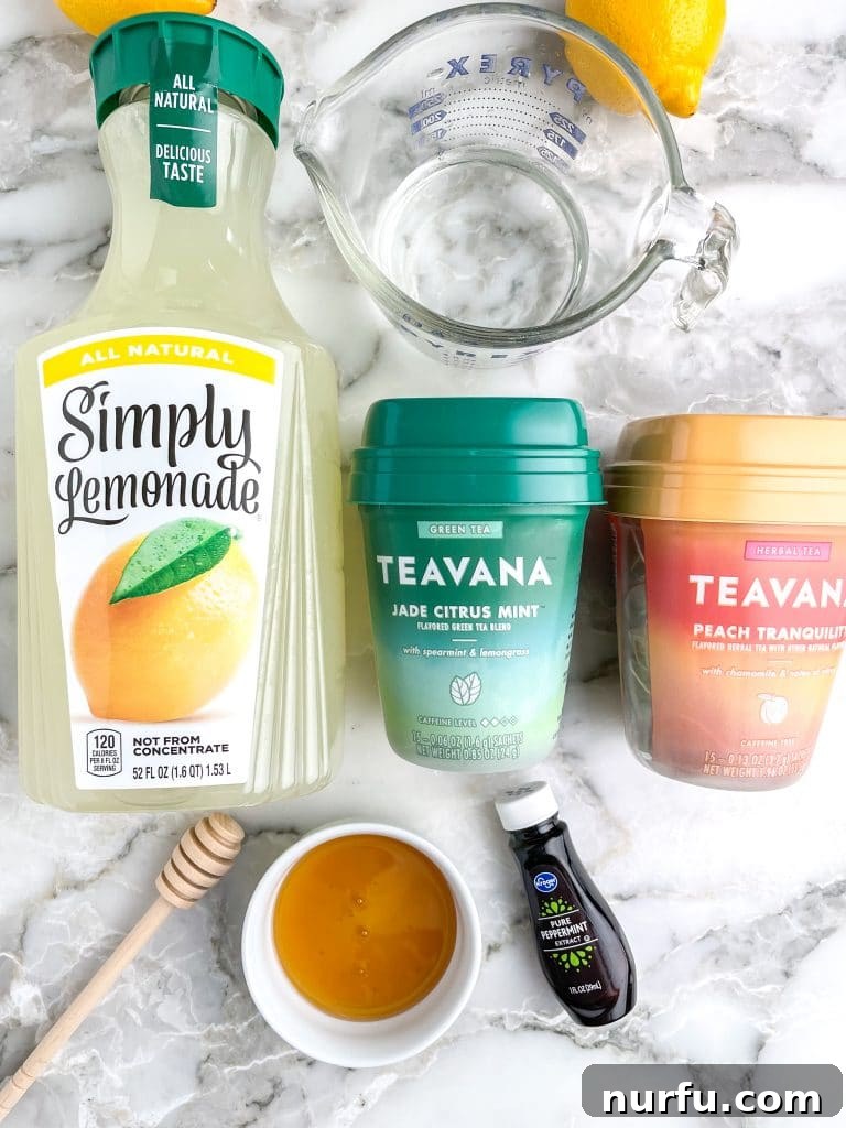 Starbucks Soothing Elixir 3 Collection of ingredients for Starbucks Medicine Ball Tea: lemonade, two types of tea bags, and a jar of honey, arranged on a kitchen counter.